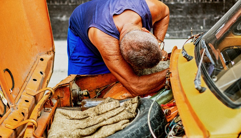 800x458 Senior man working in the hood of a car