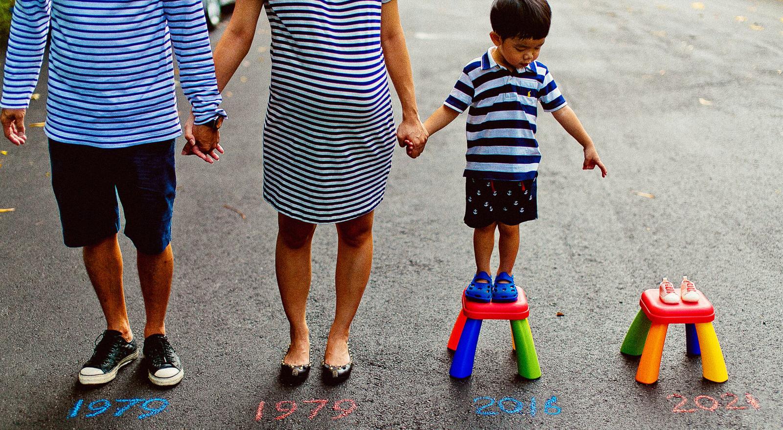 Large Web and Screen A family stands outside holding hands and looking forward to their new child