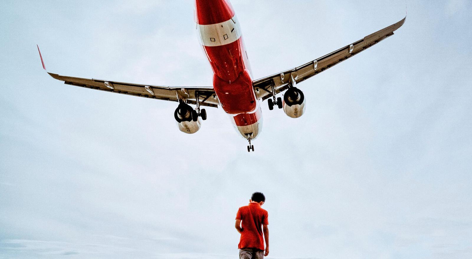 Large Web and Screen An airplane flies over a boy standing on a dock
