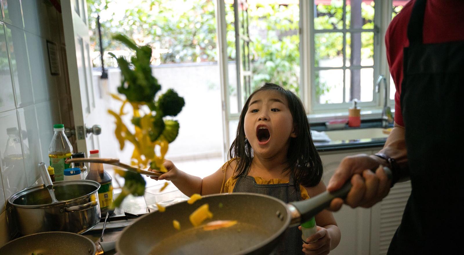 Large Web and Screen Little girl looking at her father cooking in the kitchen