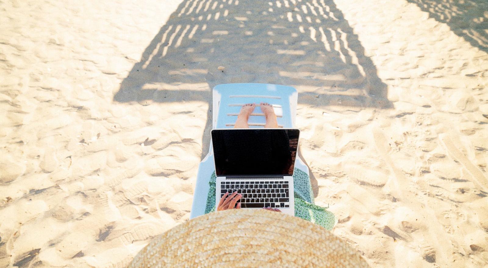 Large Web and Screen Woman uses laptop on the beach