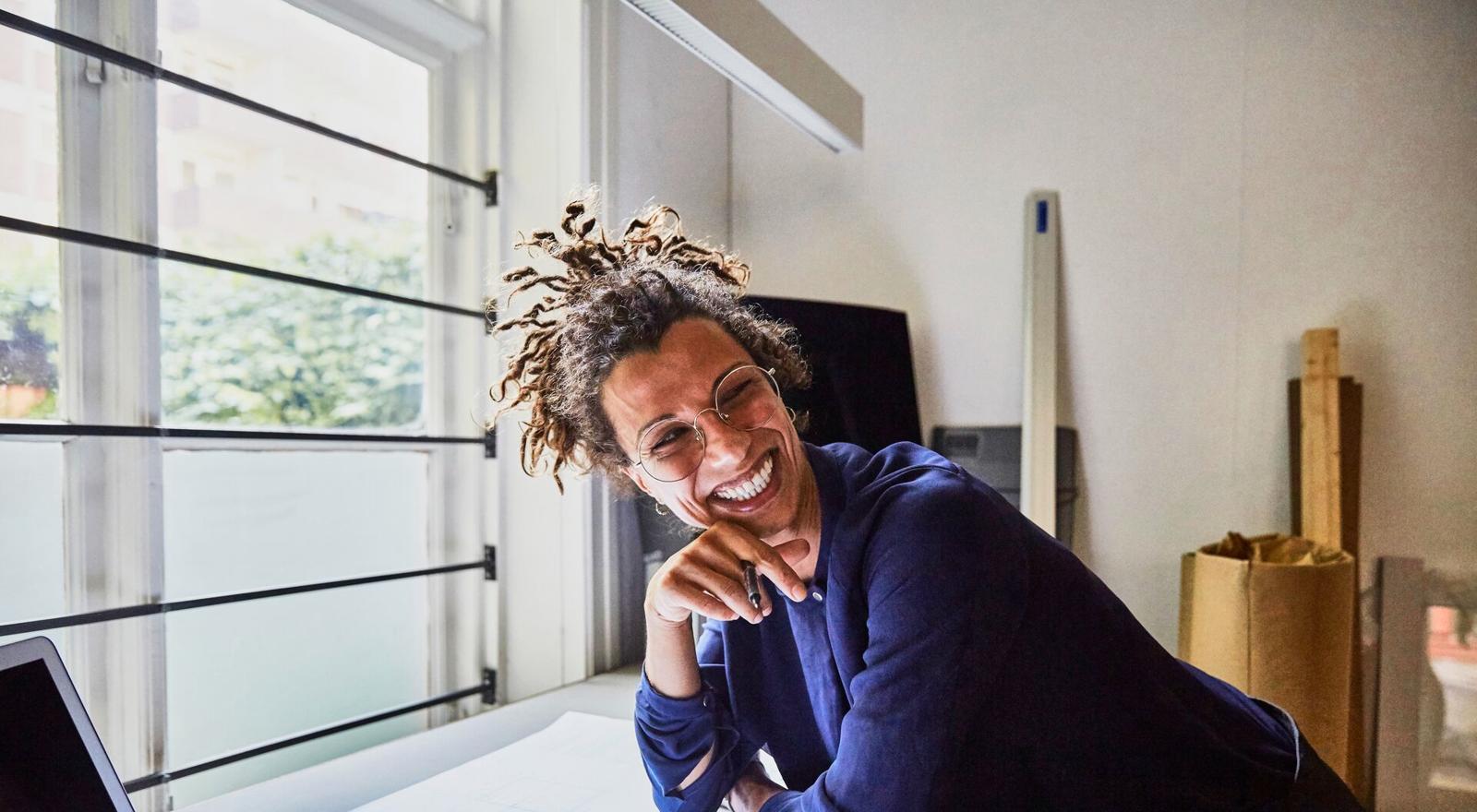 Large Web and Screen Young female professional at desk with blueprints