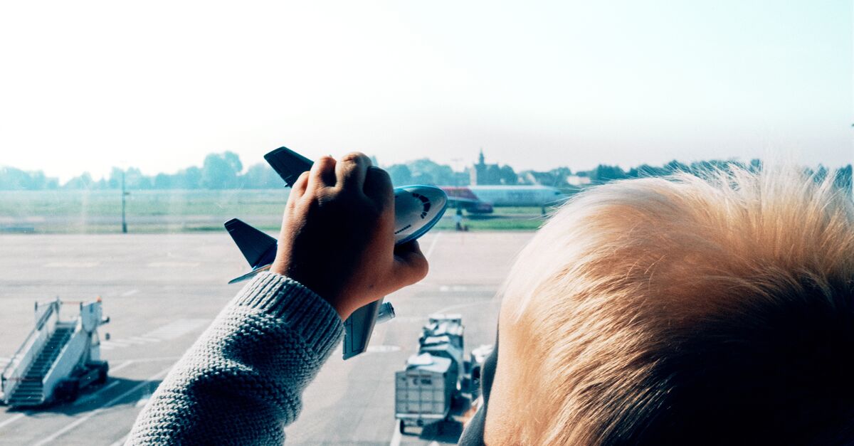 LinkedIn and Facebook Young child playing with a toy airplane at an airport