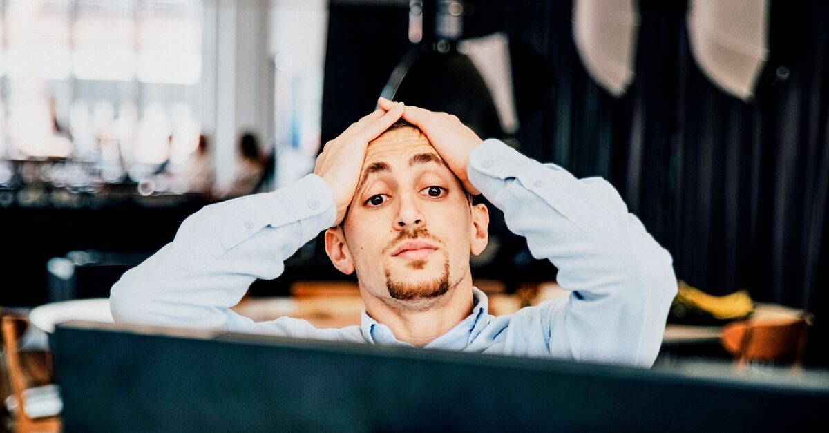 LinkedIn and Facebook Young man on computer with surprised look on his face in office setting