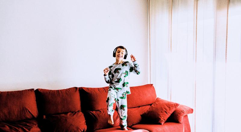 young boy is listening music on sofa